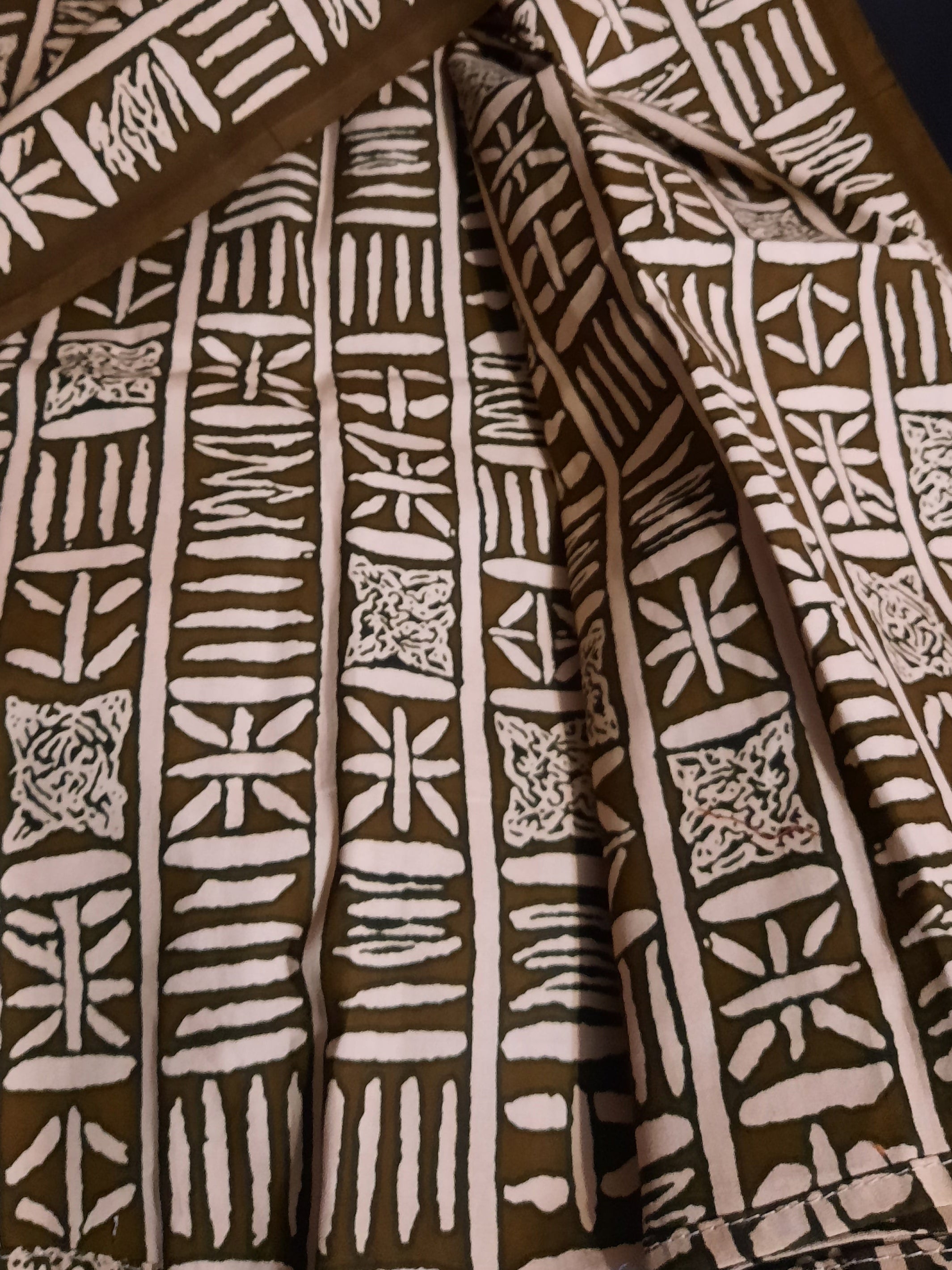 Brown fabric with white geometric patterns on a dark surface