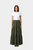 Woman wearing a white top and green tiered skirt 