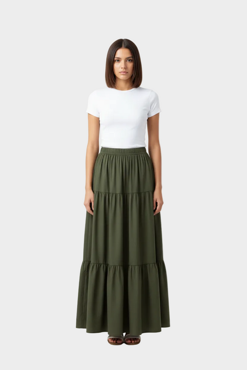 Woman wearing a white top and green tiered skirt 